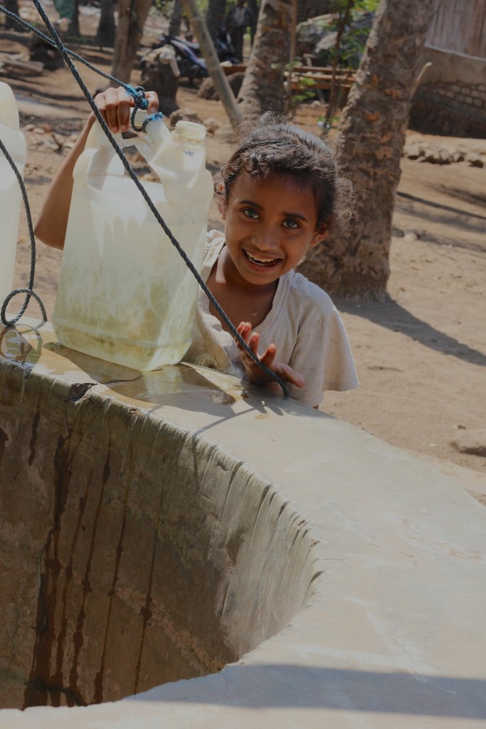 Little girl on Lembata drawing water from the village well